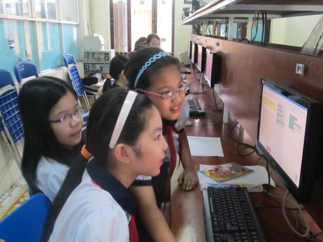 A photo showing three Vietnamese girls in front of a
computer.